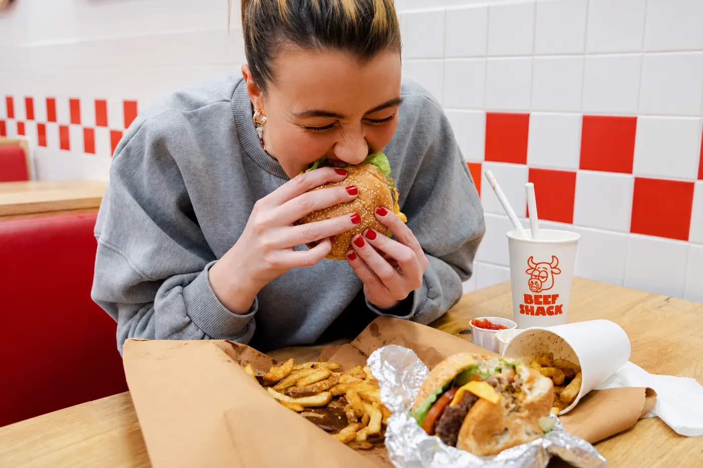 Cliente dégustant un burger Beef Shack livré